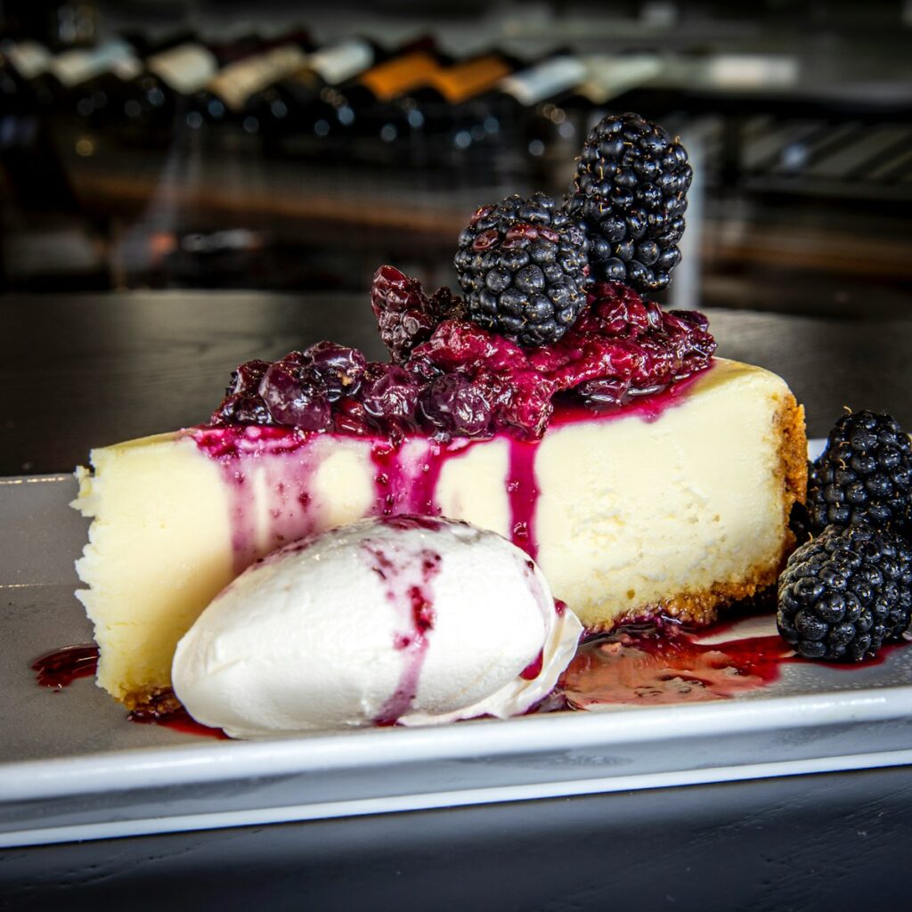 A piece of cheesecake with berries and ice cream